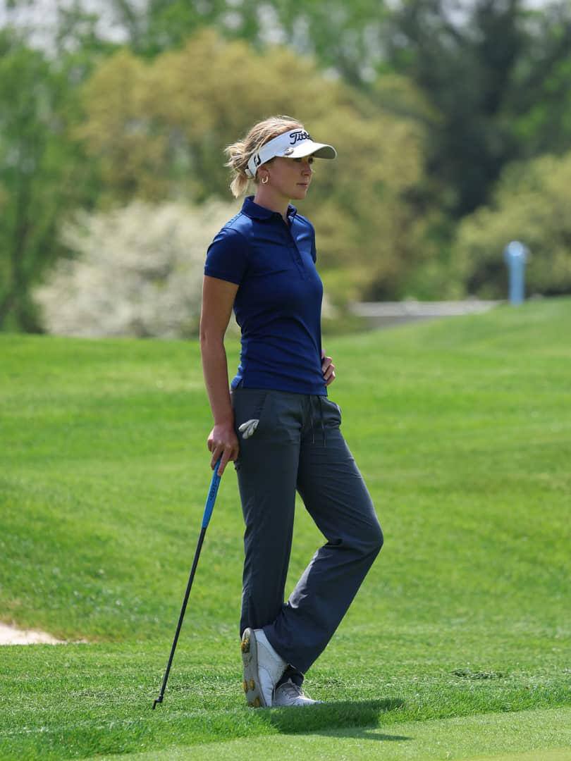 Grace Charis swinging a golf club on the course